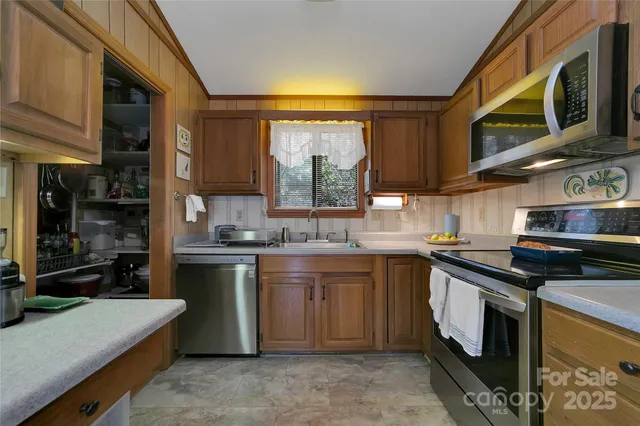 a kitchen with stainless steel appliances granite countertop a stove a sink and a microwave