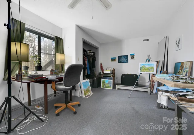 a view of a livingroom with workspace and a window