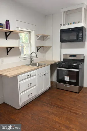 a kitchen with stainless steel appliances a stove microwave and cabinets