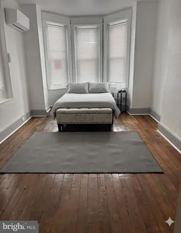 a bedroom with a bed lamp and a large window