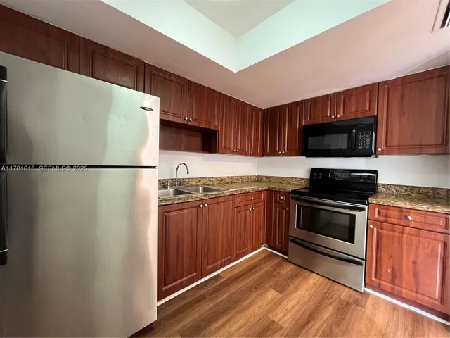 a kitchen with granite countertop a refrigerator stove and microwave