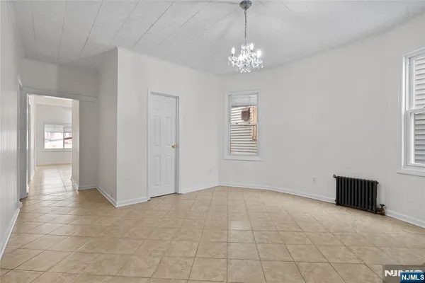 a view of a livingroom with a chandelier fan and windows