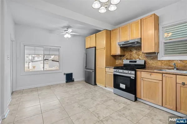 a kitchen with stainless steel appliances granite countertop a stove a sink dishwasher and a refrigerator