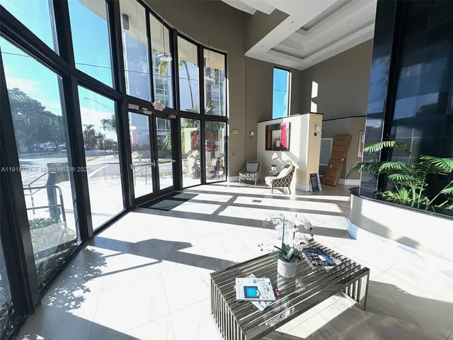 a living room with large windows and furniture