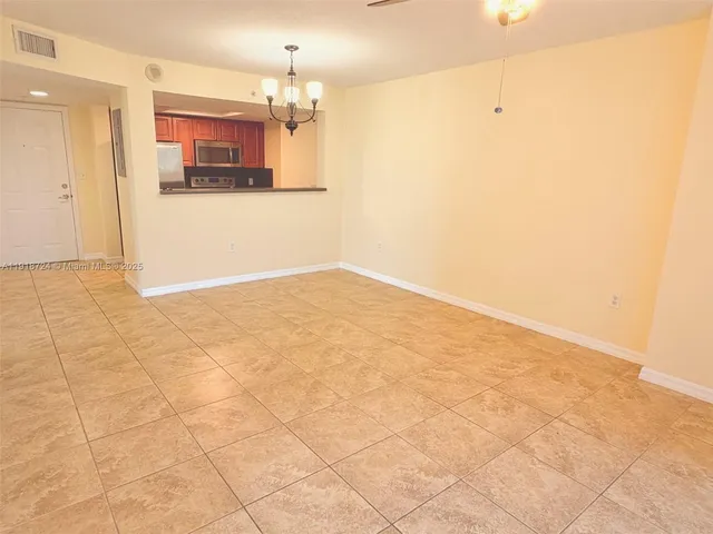 a view of a kitchen with an empty space and a chandelier