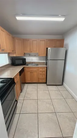 a kitchen with a sink a stove top oven and white cabinets