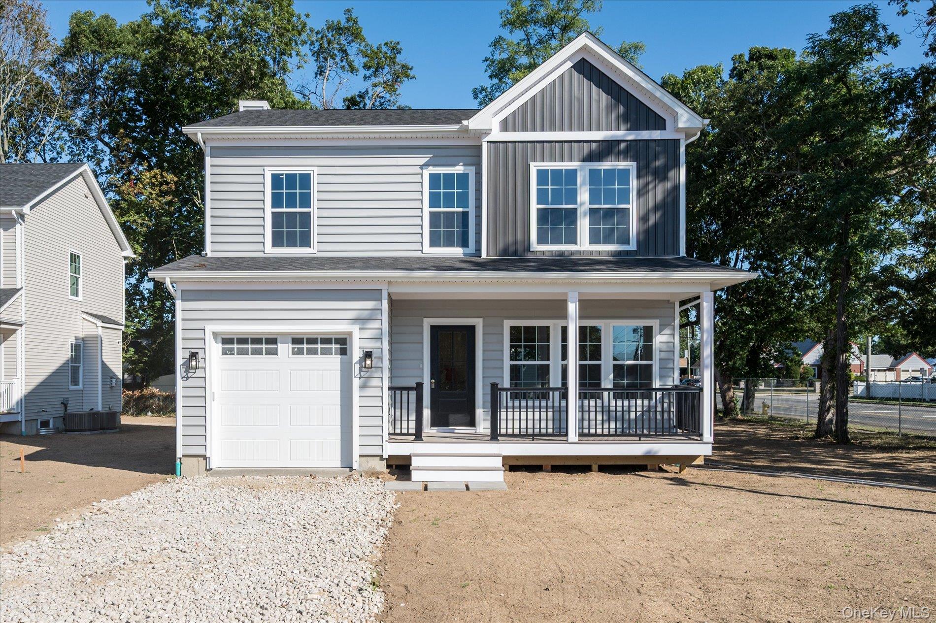 View of front of home with covered porch, board and batten siding, driveway, a chimney, and an attached garage