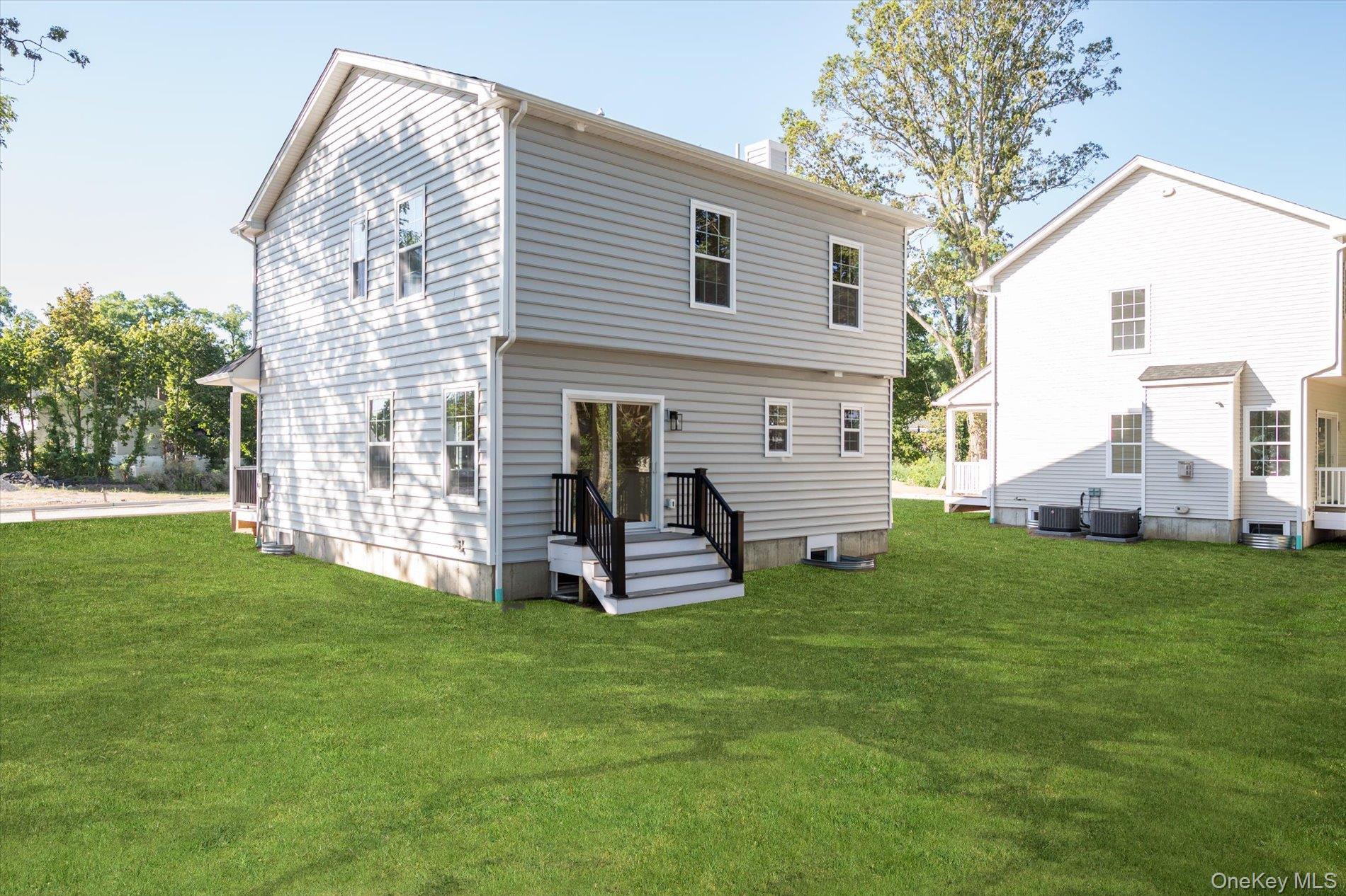 2 Gail-grace Court Copiague, NY 11726 - Photo 21 of 27 Back of property featuring a chimney and a lawn