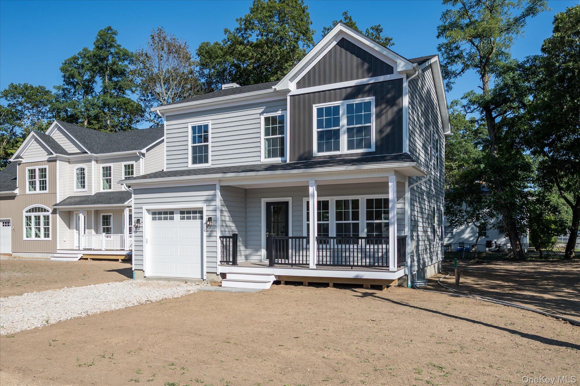 2 Gail-grace Court Copiague, NY 11726 - Photo 3 of 27 View of front of home featuring dirt driveway, a porch, board and batten siding, and an attached garage