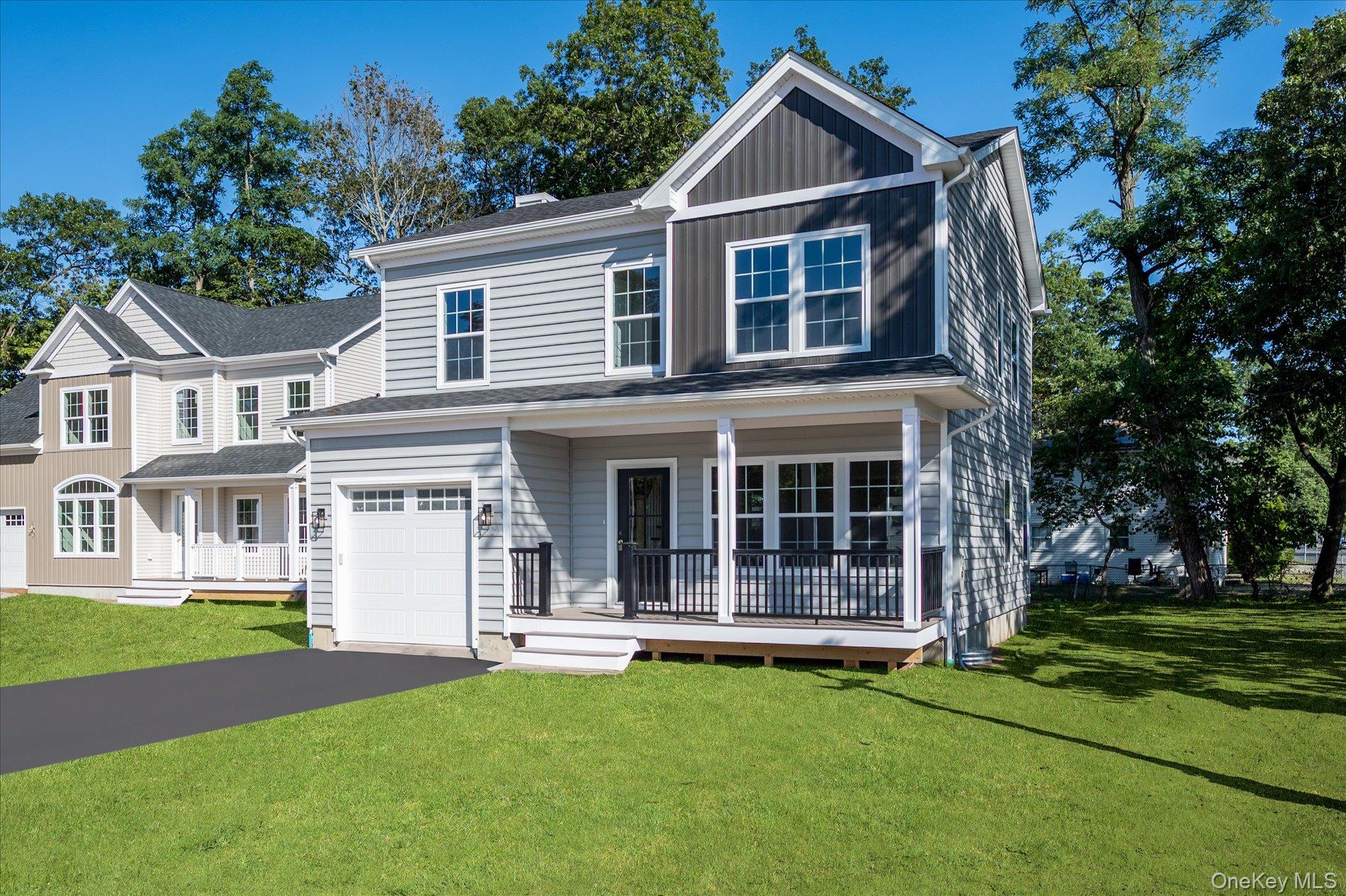 2 Gail-grace Court Copiague, NY 11726 - Photo 4 of 27 View of front facade featuring a front yard, a porch, board and batten siding, asphalt driveway, and a garage