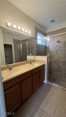 a bathroom with a sink mirror and a shower