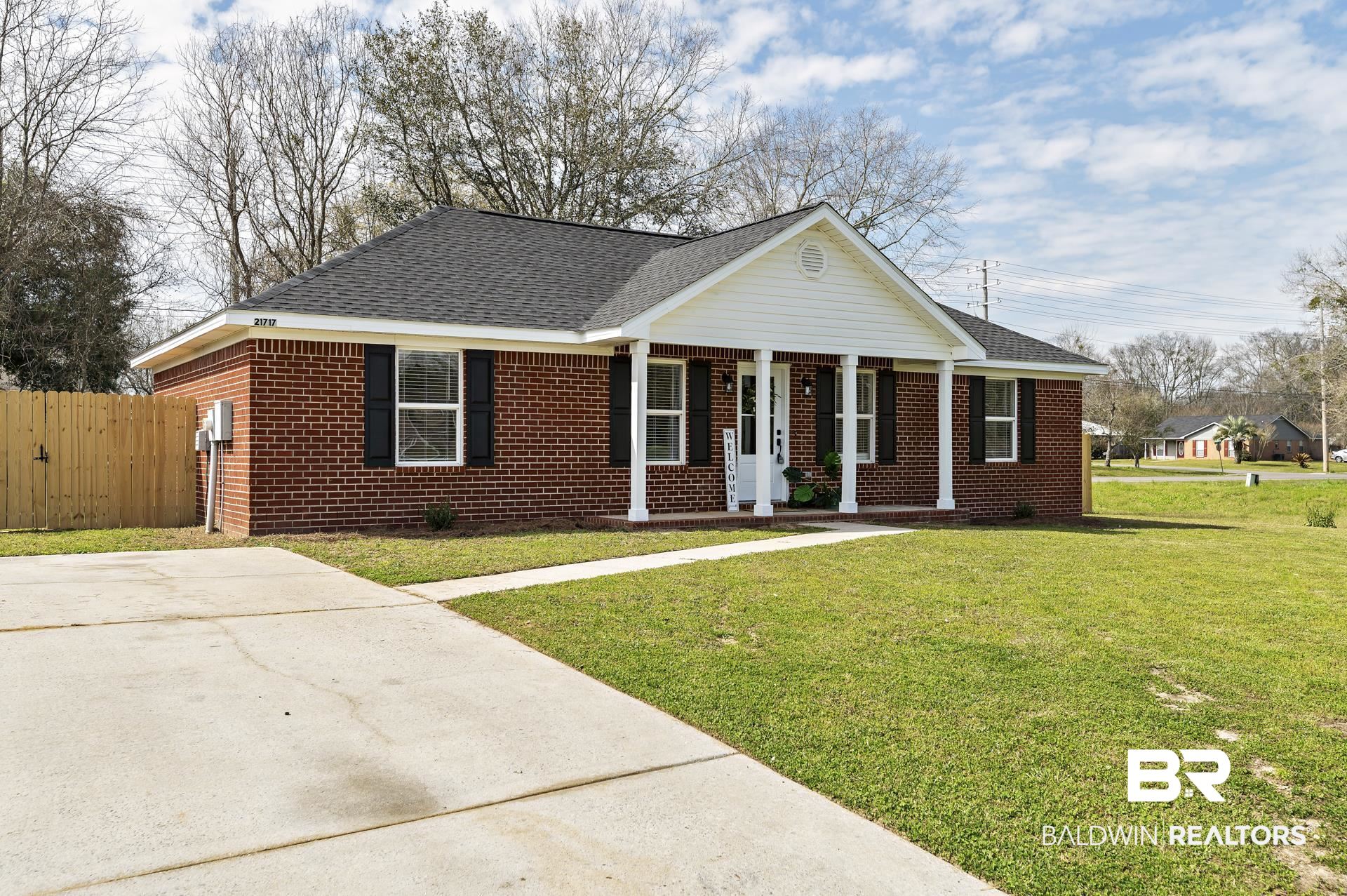 21717 Shadowbrook Street Robertsdale, AL 36567 - Photo 28 of 32 View of front of home featuring roof with shingles, fence, a front lawn, and brick siding