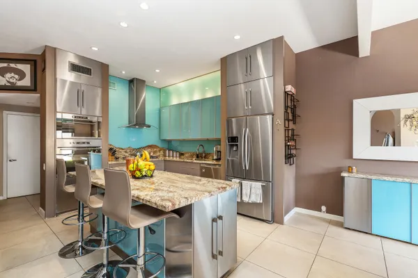 a kitchen with granite countertop a refrigerator and a stove top oven