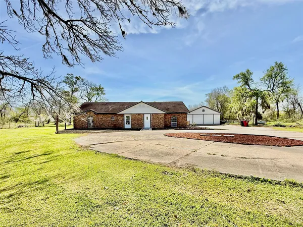 a front view of a house with a yard and trees