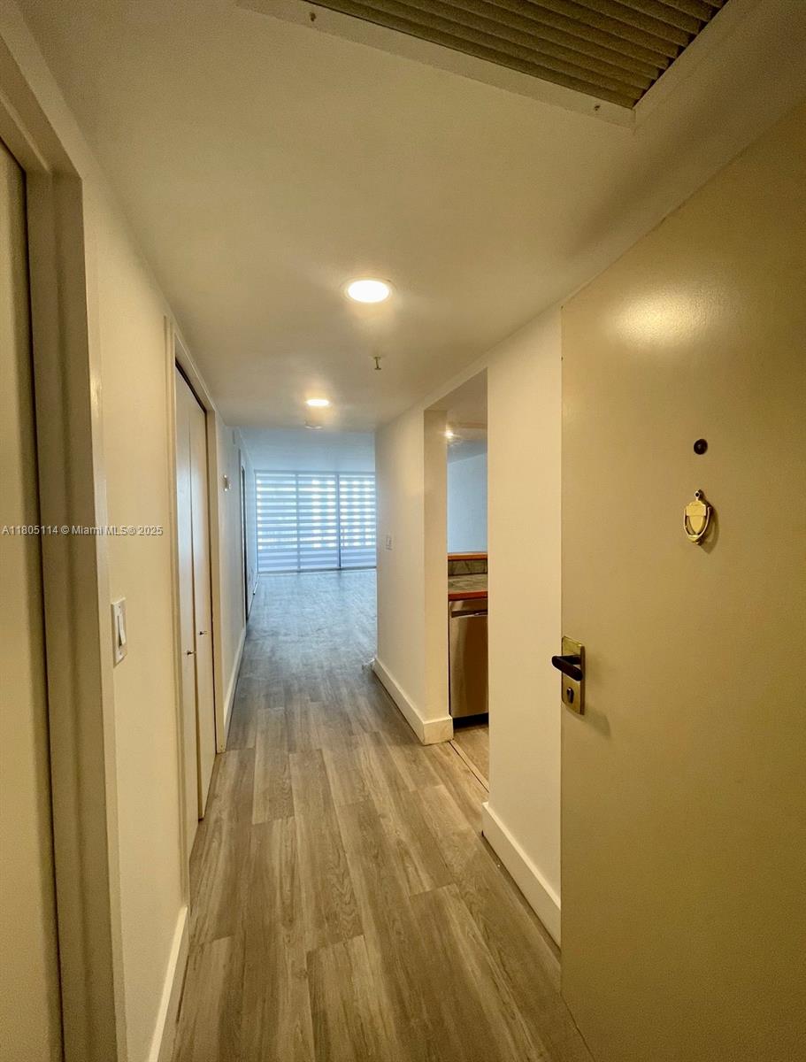 a view of a hallway with wooden floor