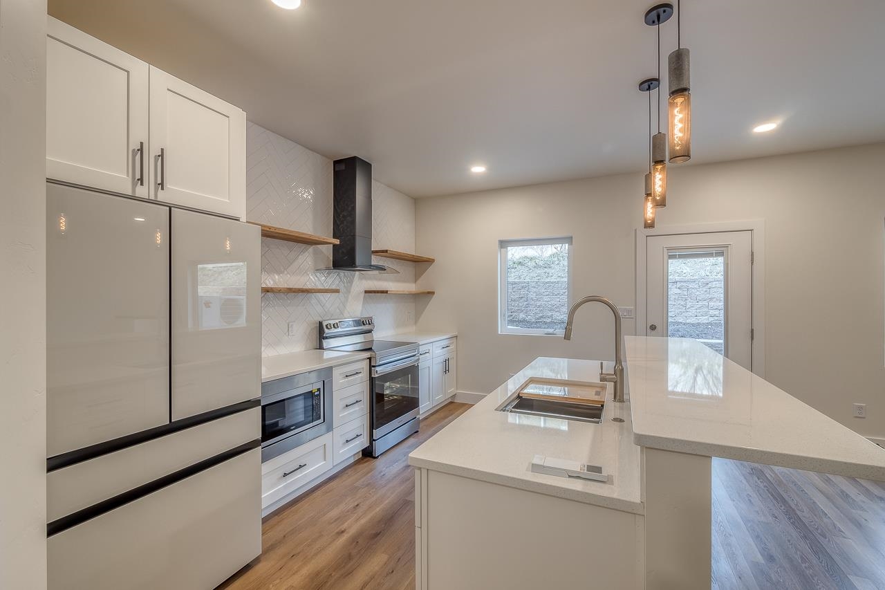 2394 Ridge Cir Drive, Unit B Grand Junction, CO 81507 - Photo 11 of 42 a kitchen with white cabinets and stainless steel appliances