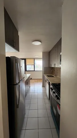 a kitchen with stainless steel appliances granite countertop a refrigerator a stove and a sink