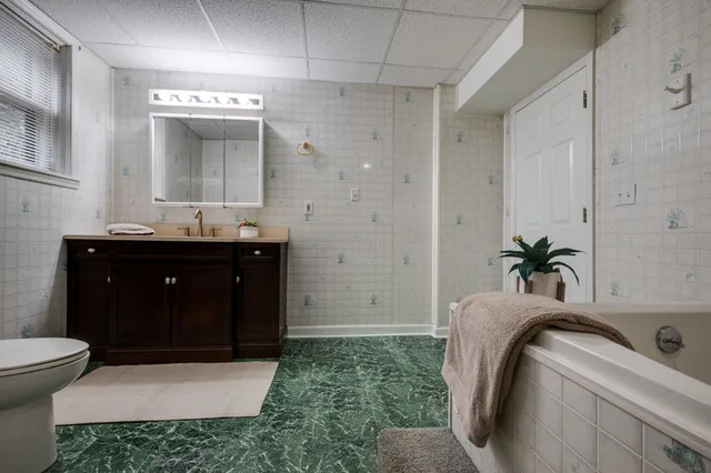 a bathroom with a sink and mirror with bathtub