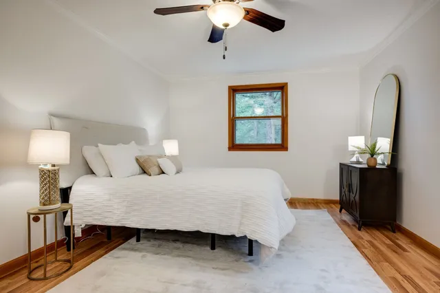 a bedroom with a bed lamp on table and a window