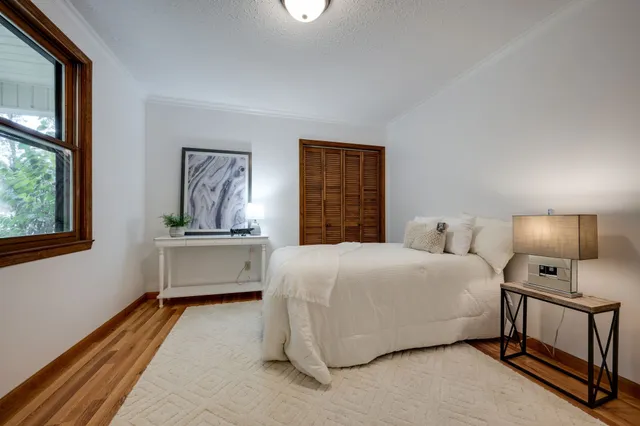 a bedroom with a bed and a large window