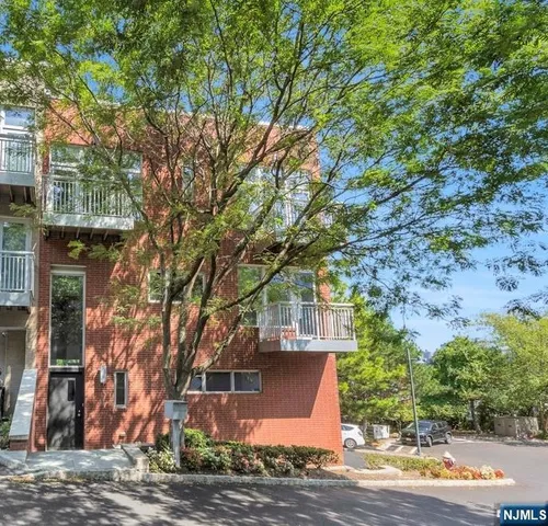 a view of a house with a tree next to a road