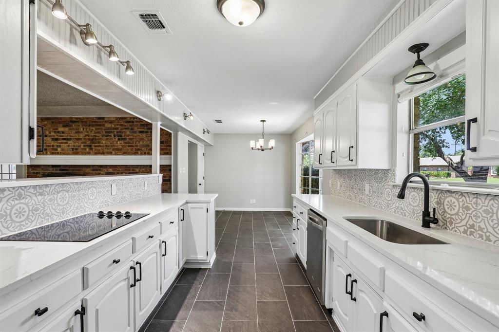 1600 South Timber Court Benbrook, TX 76126 - Photo 10 of 30 Contemporary kitchen featuring white cabinetry, integrated cooktop, stainless steel dishwasher, and a black gooseneck faucet