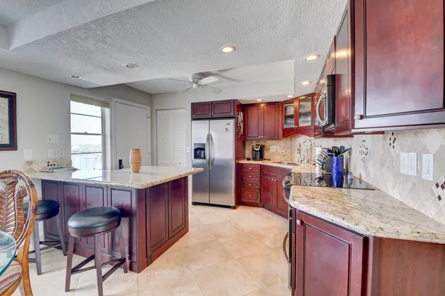 a kitchen with stainless steel appliances granite countertop a refrigerator a stove a sink and dishwasher