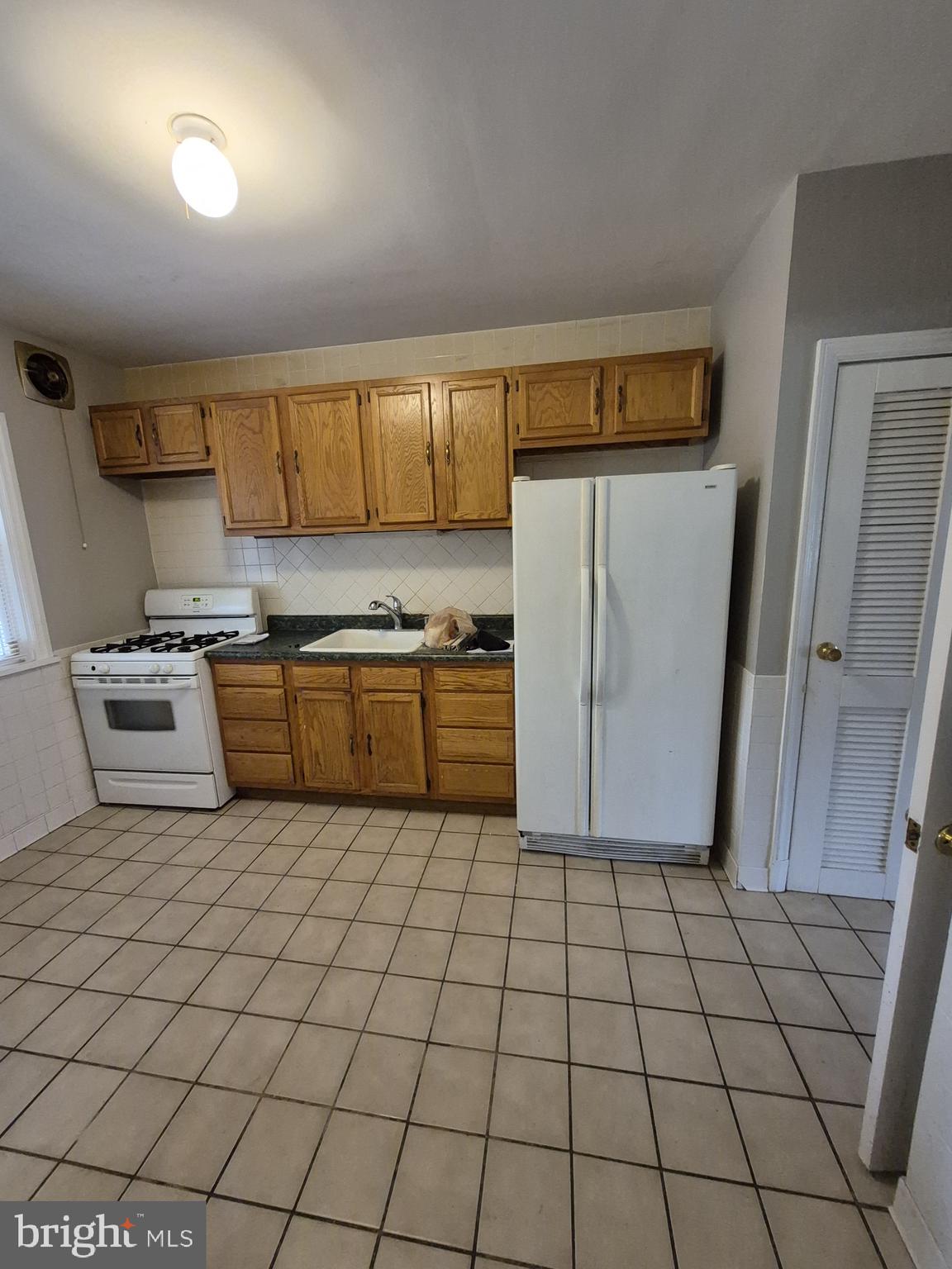 4905 Briarclift Road Baltimore, MD 21229 - Photo 12 of 41 a kitchen with a sink a stove a refrigerator and cabinets