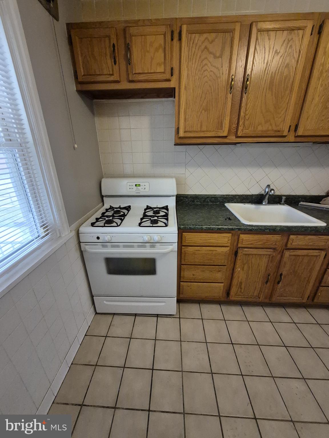 4905 Briarclift Road Baltimore, MD 21229 - Photo 13 of 41 a kitchen with granite countertop a stove sink and cabinets