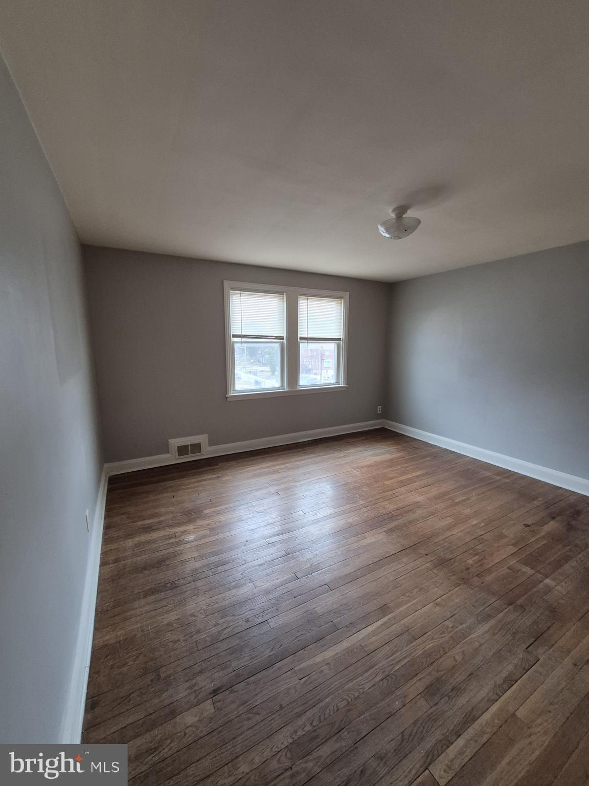 4905 Briarclift Road Baltimore, MD 21229 - Photo 14 of 41 an empty room with wooden floor and windows