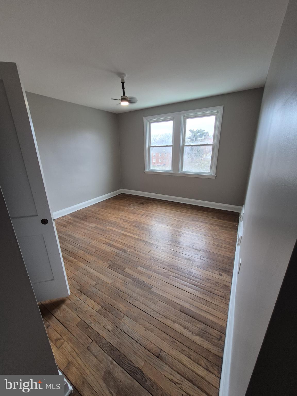 4905 Briarclift Road Baltimore, MD 21229 - Photo 17 of 41 a view of an empty room with wooden floor and a window