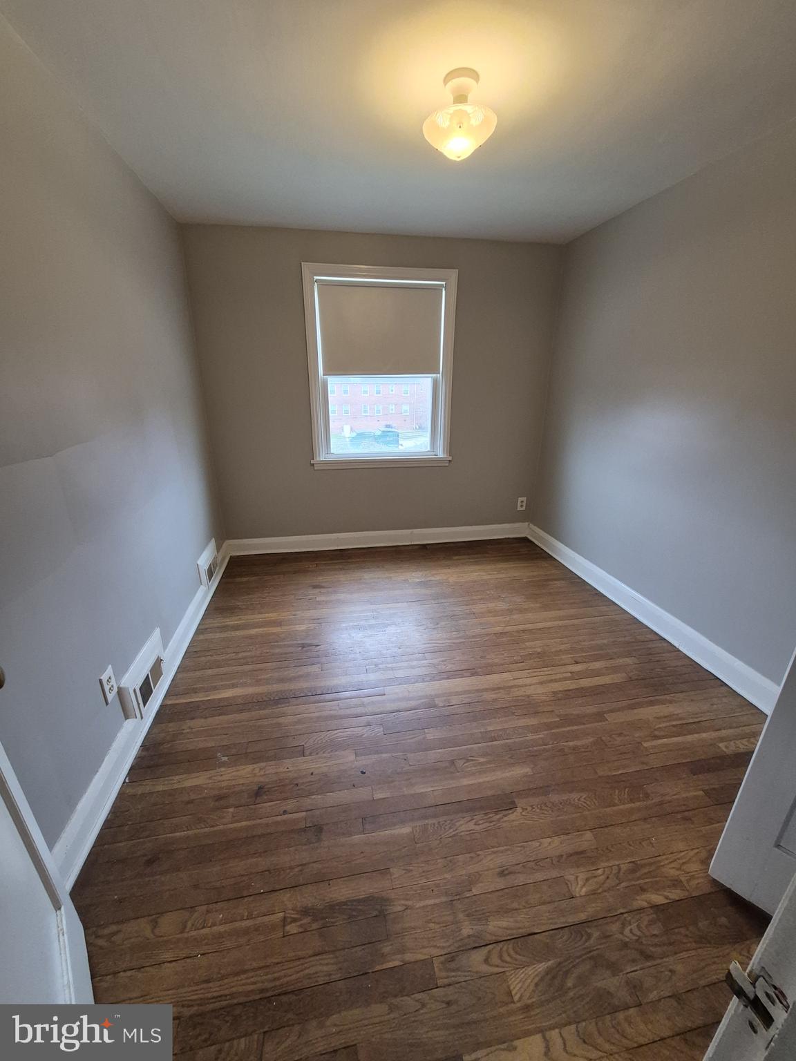 4905 Briarclift Road Baltimore, MD 21229 - Photo 22 of 41 an empty room with wooden floor and windows
