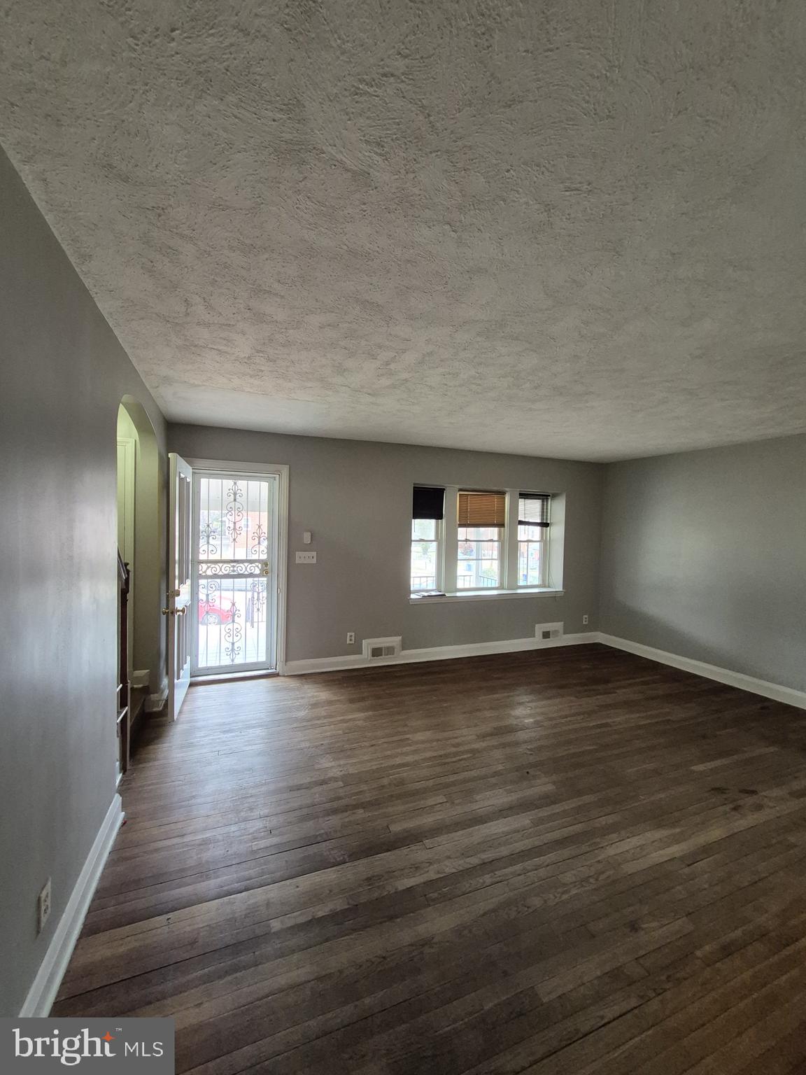 4905 Briarclift Road Baltimore, MD 21229 - Photo 5 of 41 an empty room with wooden floor and windows