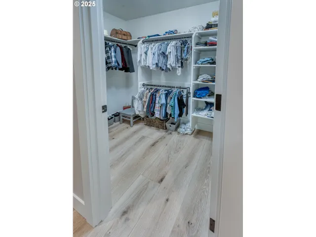 a view of walk in closet with clothes and shoes