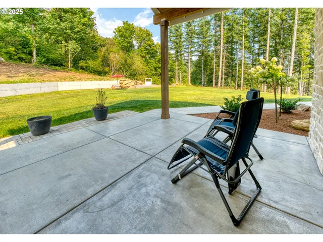 a view of a patio with a table chairs and garden