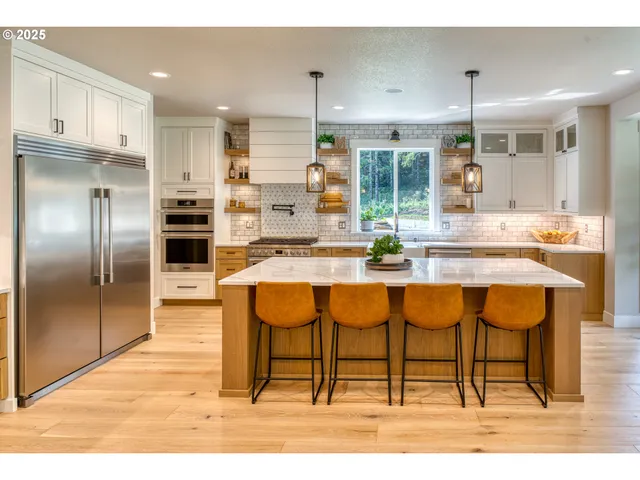 a kitchen with stainless steel appliances kitchen island granite countertop a refrigerator and cabinets