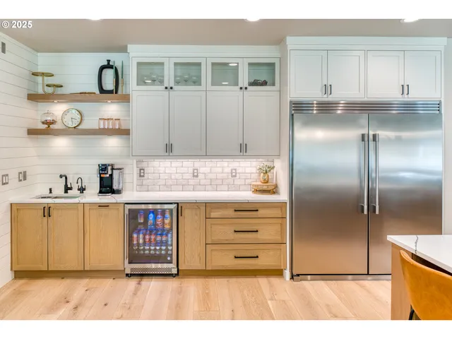 a kitchen with stainless steel appliances kitchen island granite countertop a refrigerator and cabinets