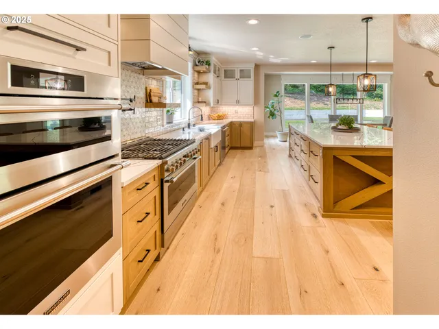 a kitchen with stainless steel appliances kitchen island granite countertop a stove and a wooden cabinets