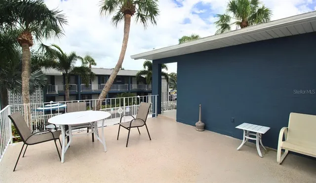 a view of a patio with table and chairs with wooden floor and fence
