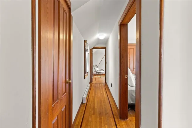 a view of a hallway with wooden floor and staircase