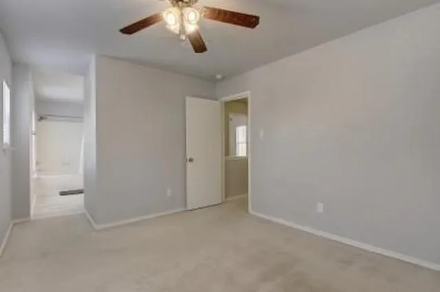 an empty room with a chandelier fan