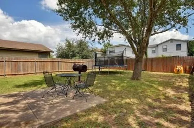 a backyard of a house with table and chairs