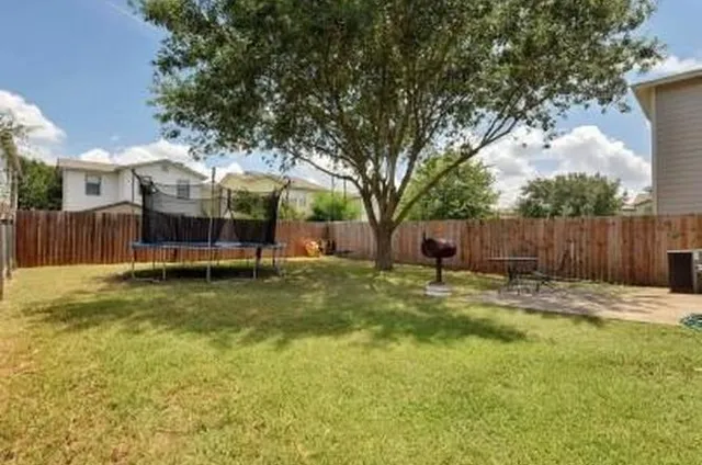 a view of a house with backyard and a tree