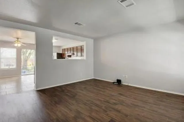 wooden floor in an empty room with a window