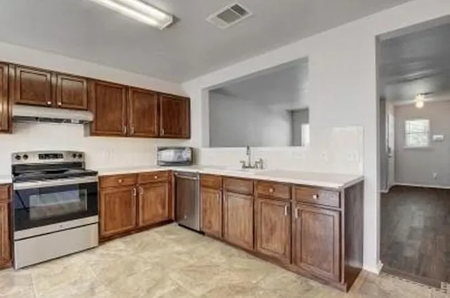 a kitchen with stainless steel appliances granite countertop a sink and a stove top oven