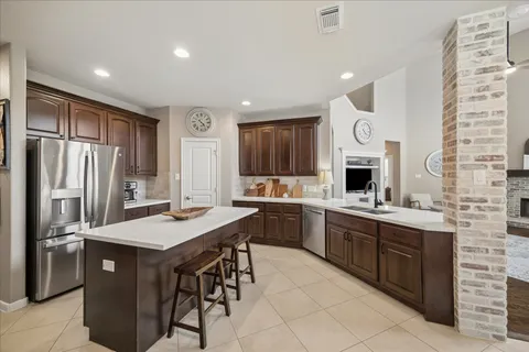 a kitchen with a sink refrigerator and cabinets
