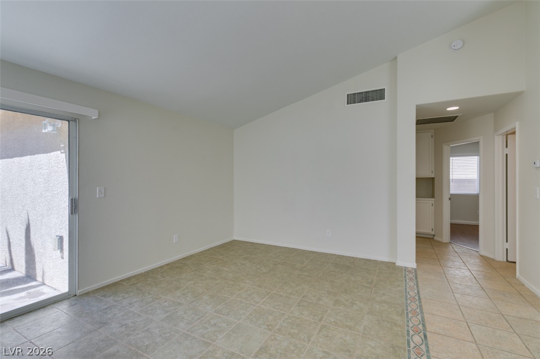 307 Cavalla Street Henderson, NV 89074 - Photo 12 of 44 A spacious, naturally illuminated room featuring vaulted ceilings and durable tile flooring throughout.