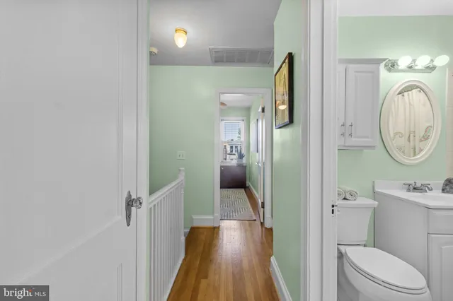 a bedroom with a bed a mirror on dresser and a chandelier