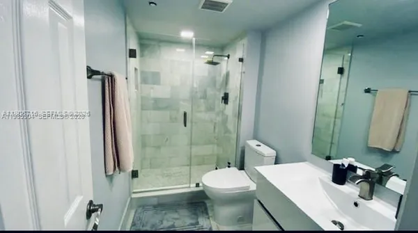 a bathroom with a sink a toilet and shower