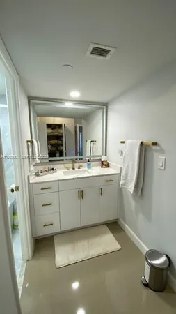 a bathroom with a sink a toilet and mirror